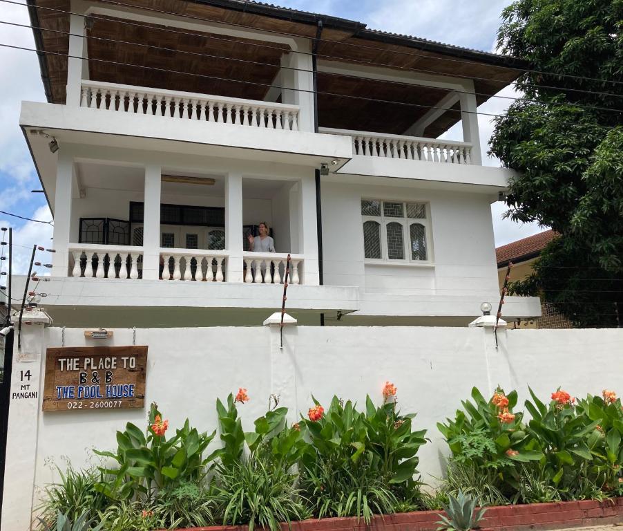 two people standing on the balcony of a house at The Place to B&B - The Poolhouse in Dar es Salaam