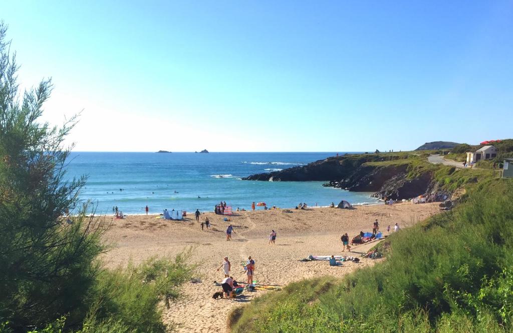 a group of people on a beach near the ocean at 50m FROM THE BEACH, dogs welcome in St Merryn