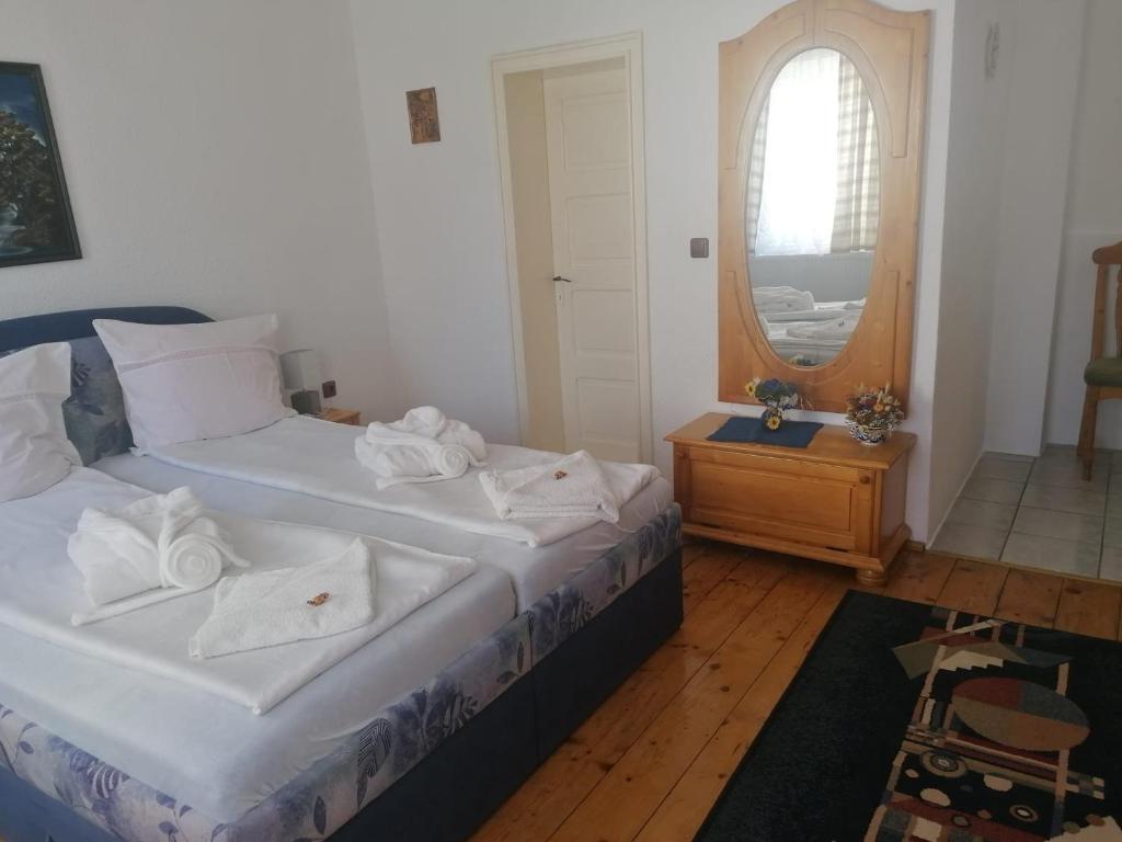a bedroom with two twin beds and a mirror at Pensiunea Spack in Cristian