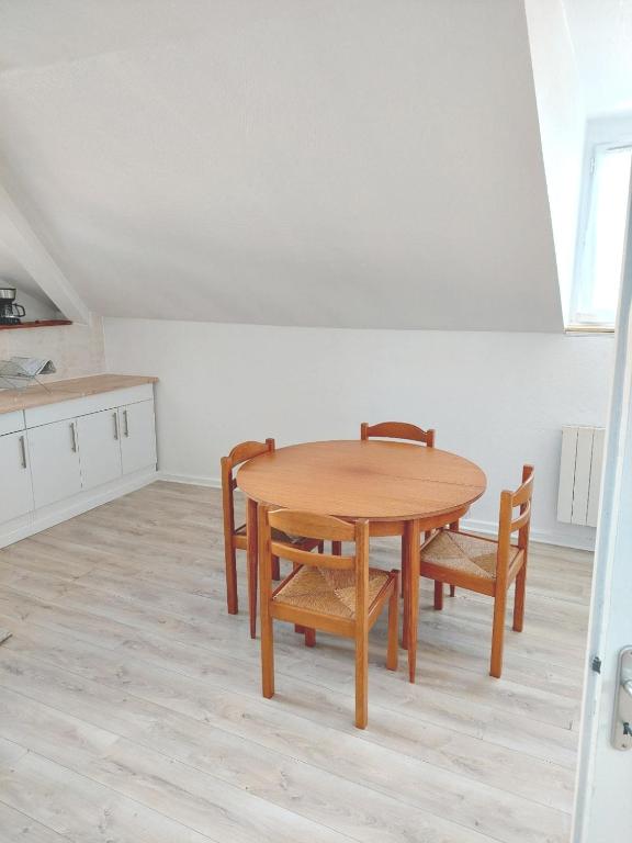 une salle à manger avec une table et des chaises en bois dans l'établissement Appartement confortable à Rosny-sous-Bois, 38m² + Vue sur la ville, à Rosny-sous-Bois