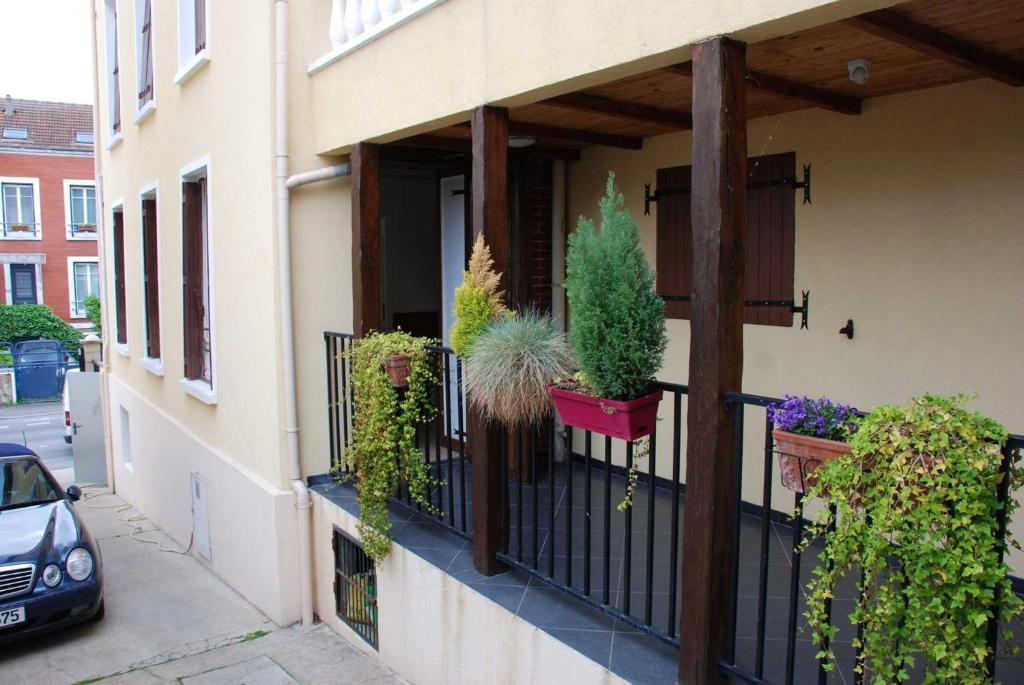 a balcony with potted plants on a building at Appartement confortable à Rosny-sous-Bois, 38m² + Vue sur la ville in Rosny-sous-Bois