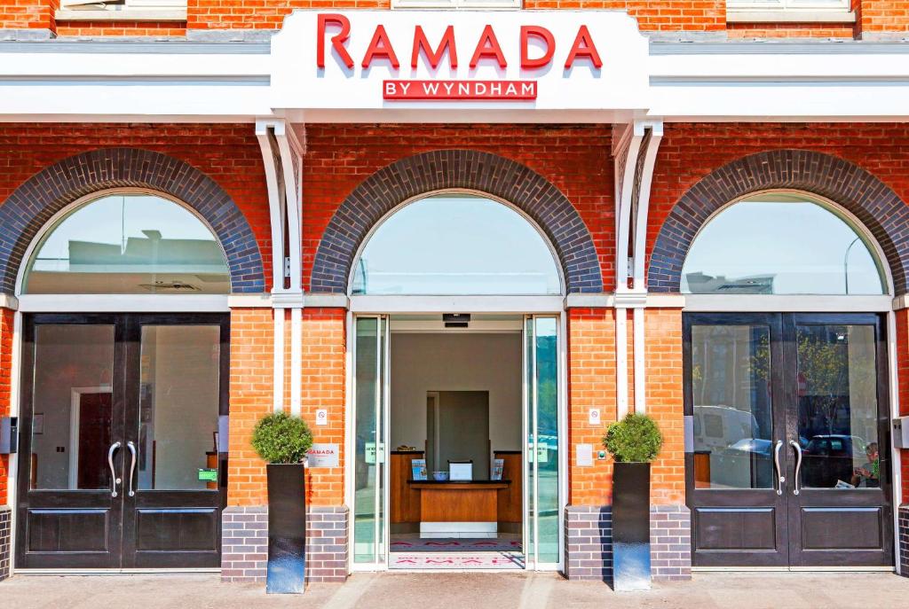 a red brick building with three arched entry doors at Ramada by Wyndham Belfast in Belfast