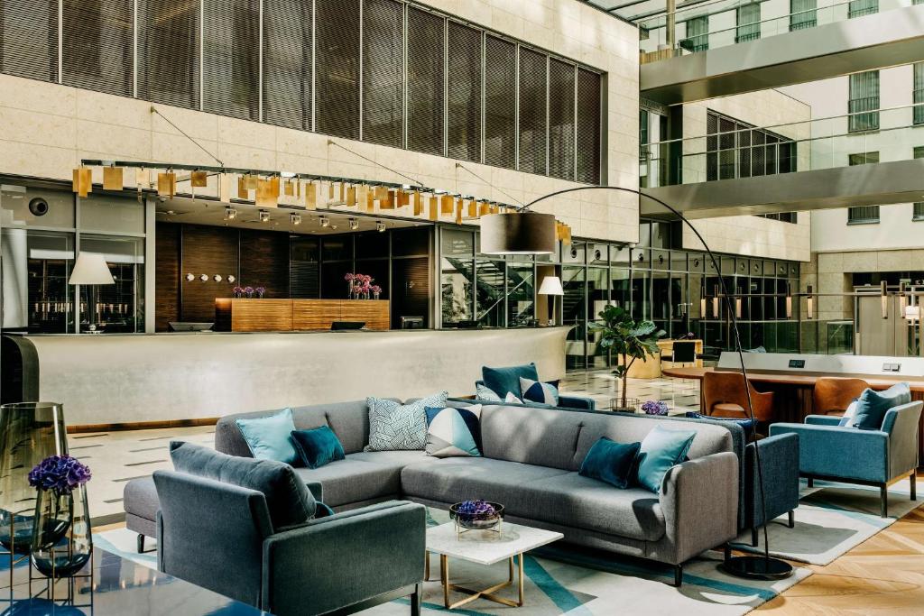 a lobby with a couch and chairs in a building at Hotel Kö59 Düsseldorf - Member of Hommage Luxury Hotels Collection in Düsseldorf