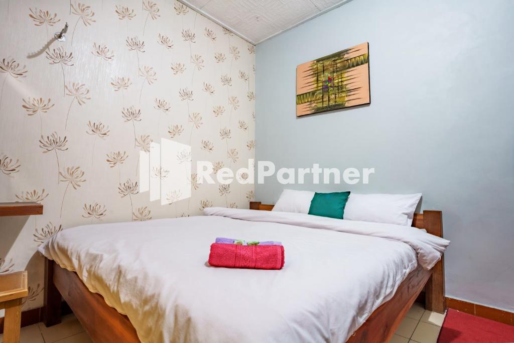 a bedroom with a bed with a red container on it at Nafisa Homestay Syariah Near Jatim Park 3 Batu Mitra RedDoorz in Malang