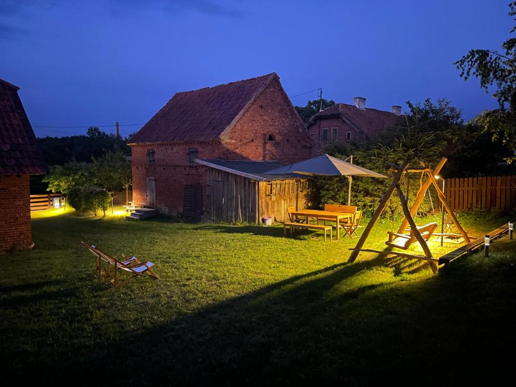 un cortile con parco giochi e un fienile di notte di Na Końcu Świata a Pozezdrze