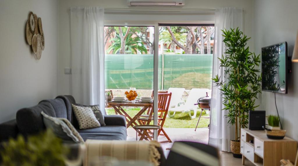 a living room with a couch and a table and a patio at Açoteias B3 in Albufeira