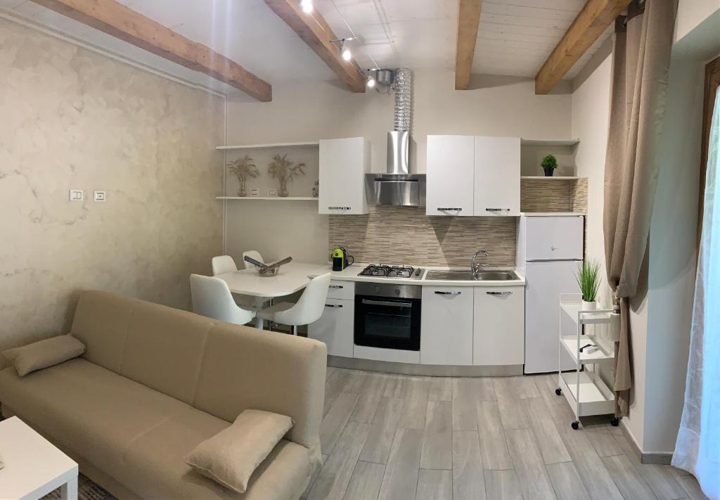 kuchnia i salon z kanapą i stołem w obiekcie La Casetta di Anna, Terni w mieście Terni