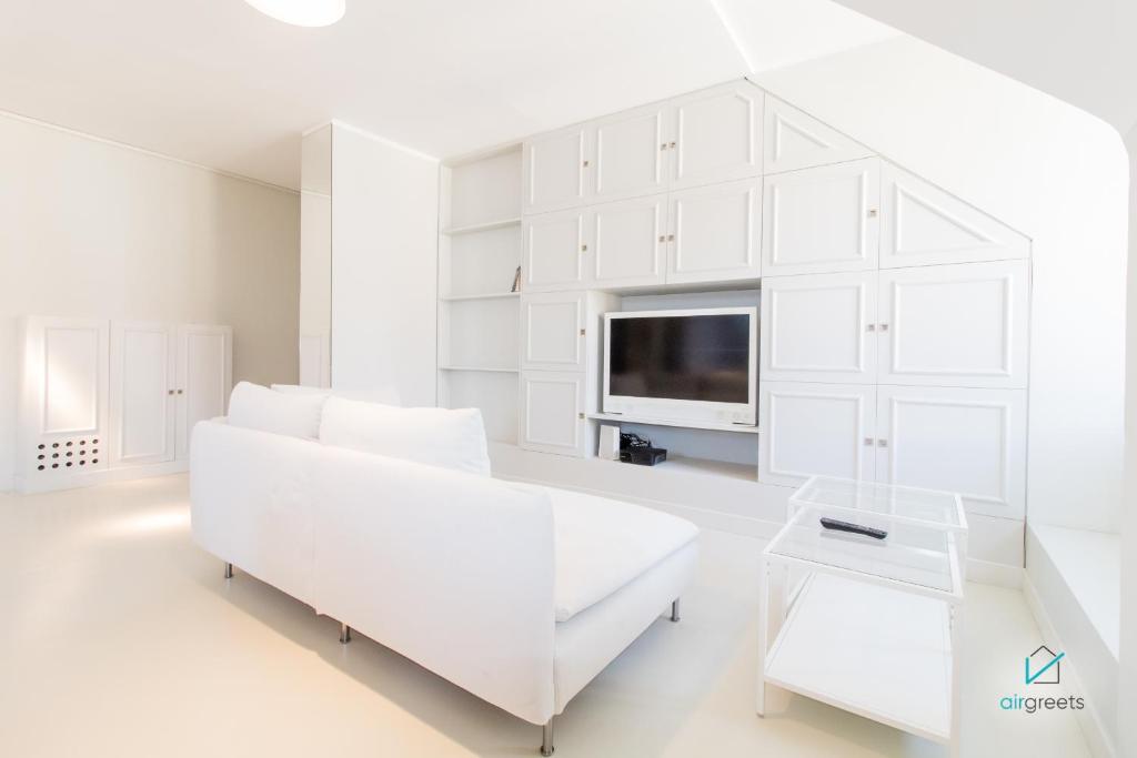un salon blanc avec un canapé blanc et une télévision dans l'établissement MODERN, MINIMALIST FLAT IN VIENNA, à Vienne
