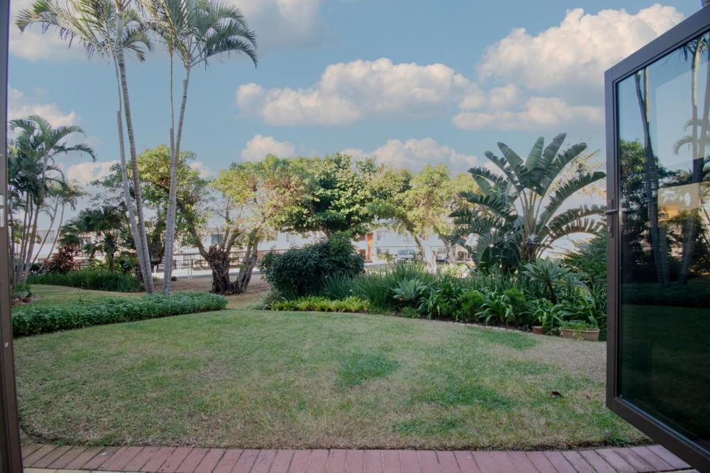 a garden with palm trees and a lawn at 7 The Shades Umhlanga Rocks in Durban
