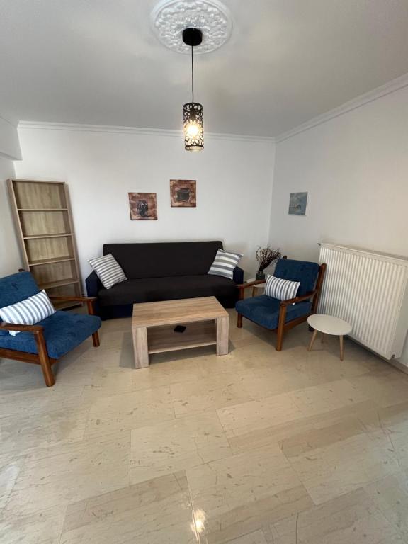 uma sala de estar com um sofá e duas cadeiras em Nantia Apartment em Myrina