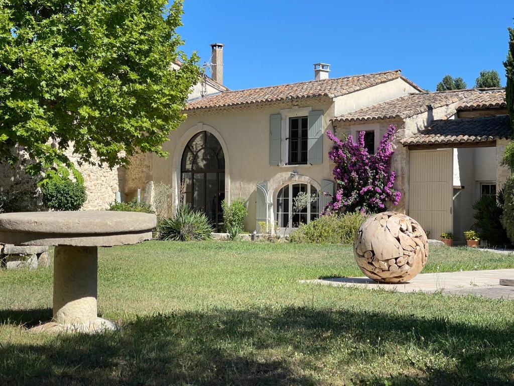 a house with a large ball in the yard at MAS MILLÉSIME - Chambre double - petit déjeuner - piscine - Mas du XVIIIème siècle proche Saint-Rémy-de-Provence in Mas blanc des Alpilles