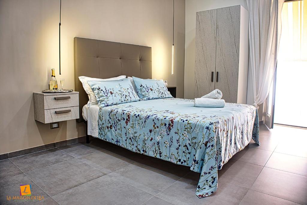 - une chambre dotée d'un lit avec une couverture bleue et blanche dans l'établissement La maison di Lea, à Gaète