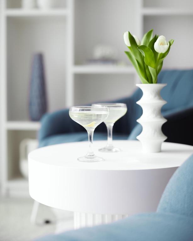 a table with two glasses and a vase on it at St Moritz Hotel and Cowshed Spa in Polzeath