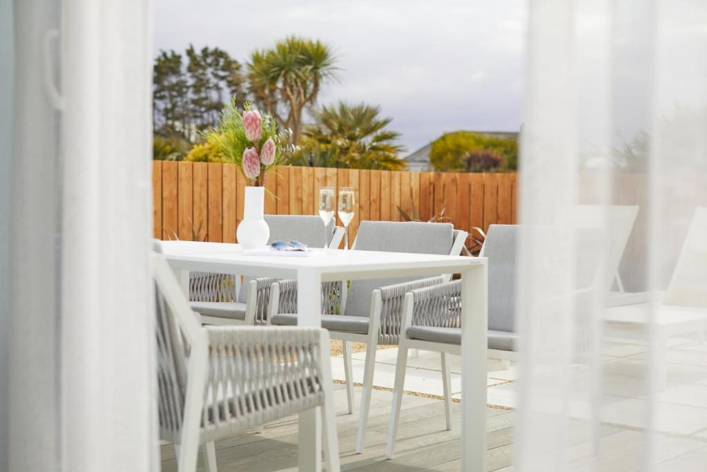a white table and chairs with a vase on it at St Moritz Hotel and Cowshed Spa in Polzeath