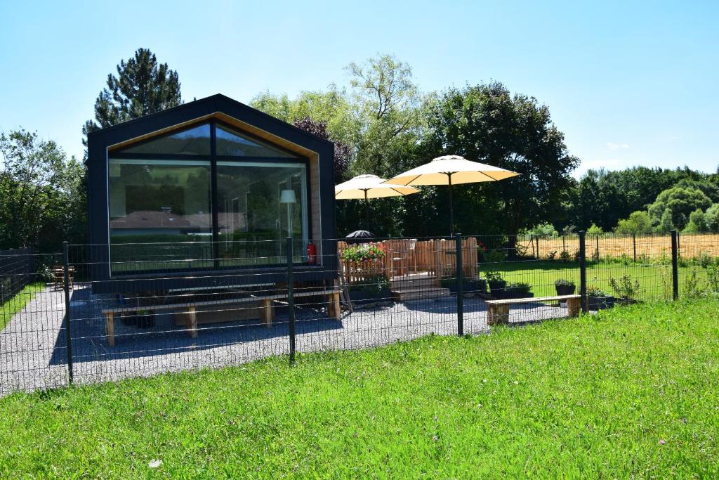 eine kleine Hütte auf einem Feld mit einem Regenschirm in der Unterkunft Luxus Ferien-Lodge Lurger-Fasching in Rohrbach An Der Gölsen