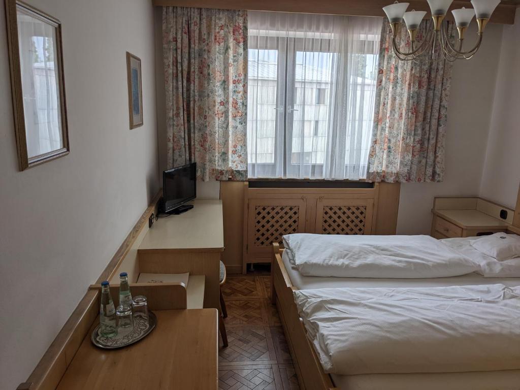 a hotel room with two beds and a window at Hotel Neuwirt in Zorneding