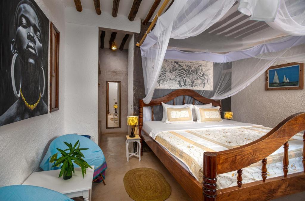 a bedroom with a canopy bed and a chair at Villa Lala in Kiwengwa