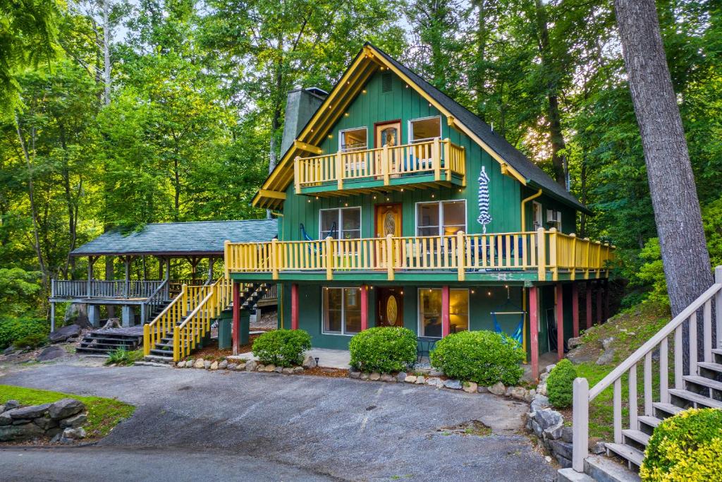 a green house with a balcony and a porch at Chimney Rock Chalet Near Lake Lure! in Chimney Rock