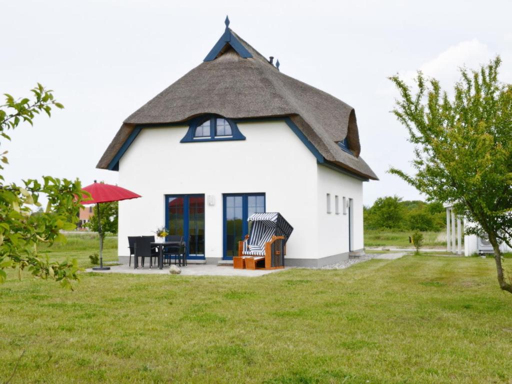 a small white house with a thatched roof at Villa Fasan in Trent