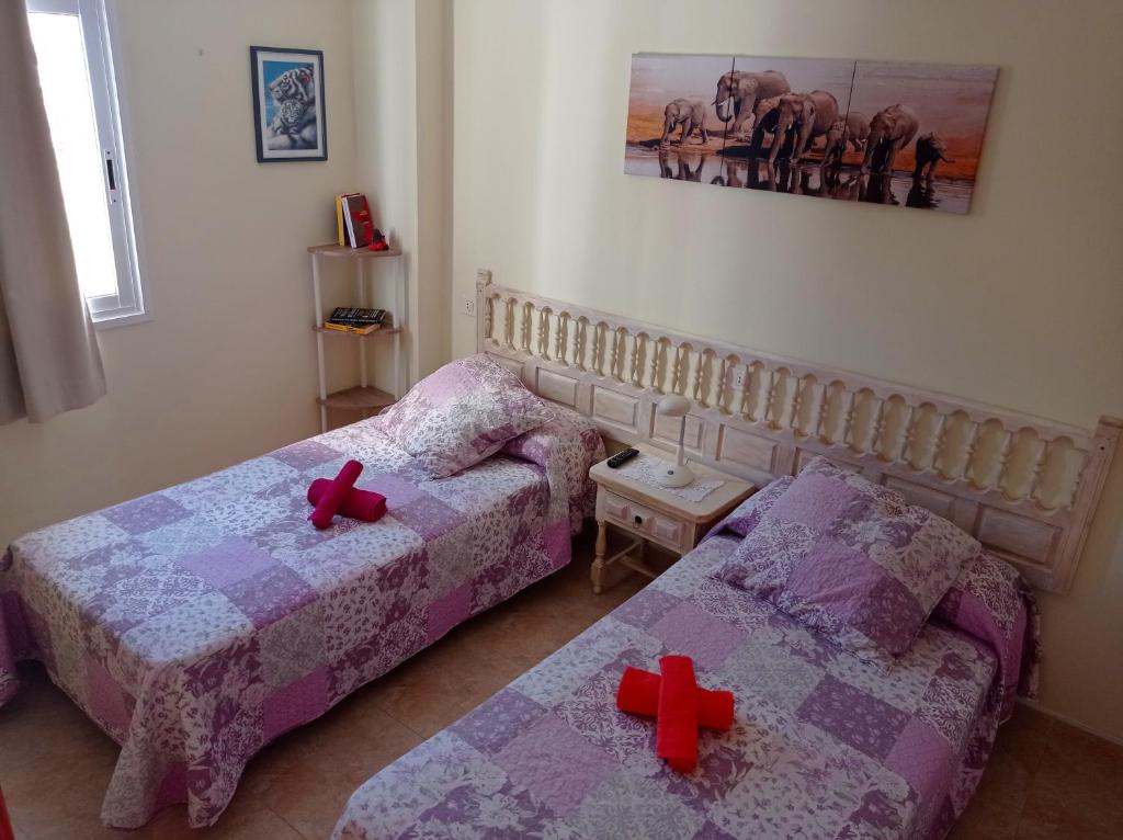 una camera con due letti con croci di ELDORADO 2 BEDROOMS a Playa de las Americas