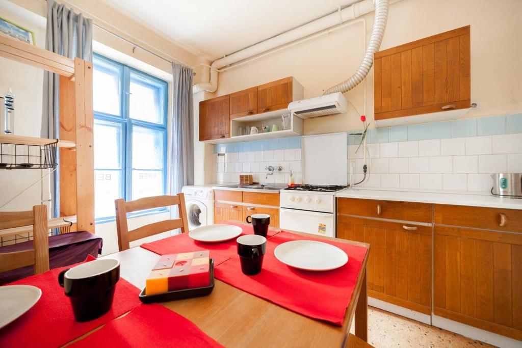 Heroes Square & City Park Thermals Apartment في بودابست: مطبخ مع طاولة خشبية مع قطعة قماش من الطاولة الحمراء
