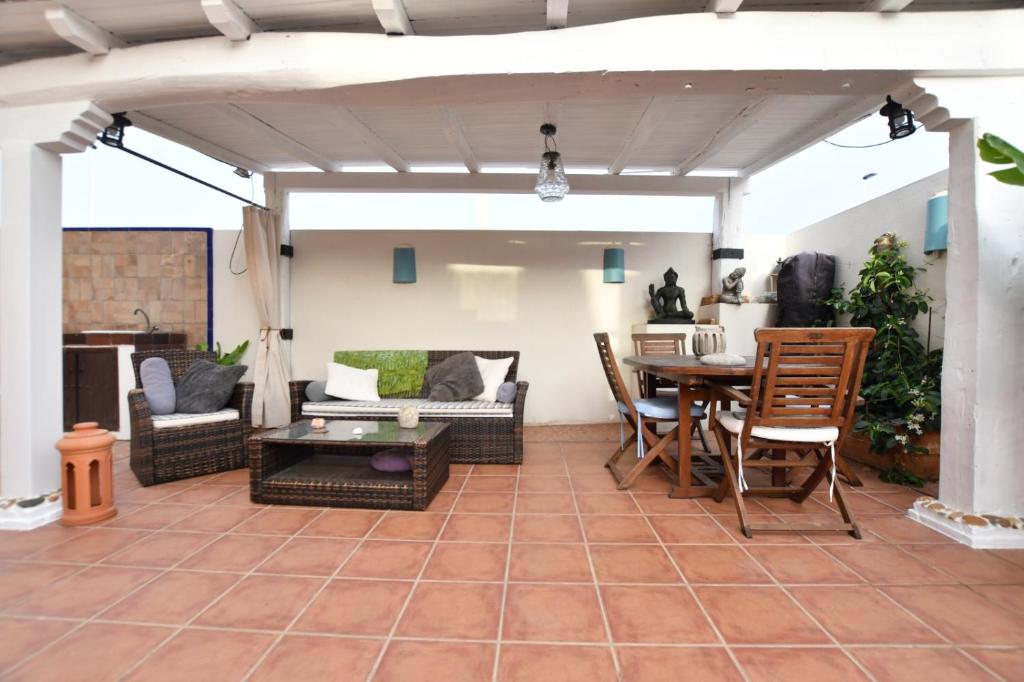 a patio with a table and chairs and a couch at Merecido Descanso Sun Beach in Torrevieja