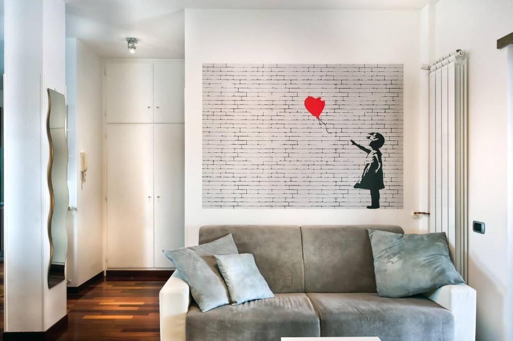 a living room with a couch and a red heart on the wall at A casa di DiGi - Appartment at last floor with panoramic view in Albano Laziale