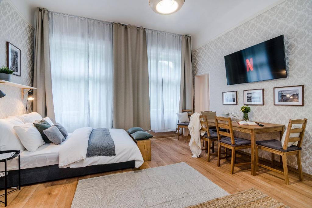 プラハにあるHistoric Centre Prague Apartments by Michal&Friendsのベッド、テーブル、デスクが備わる客室です。