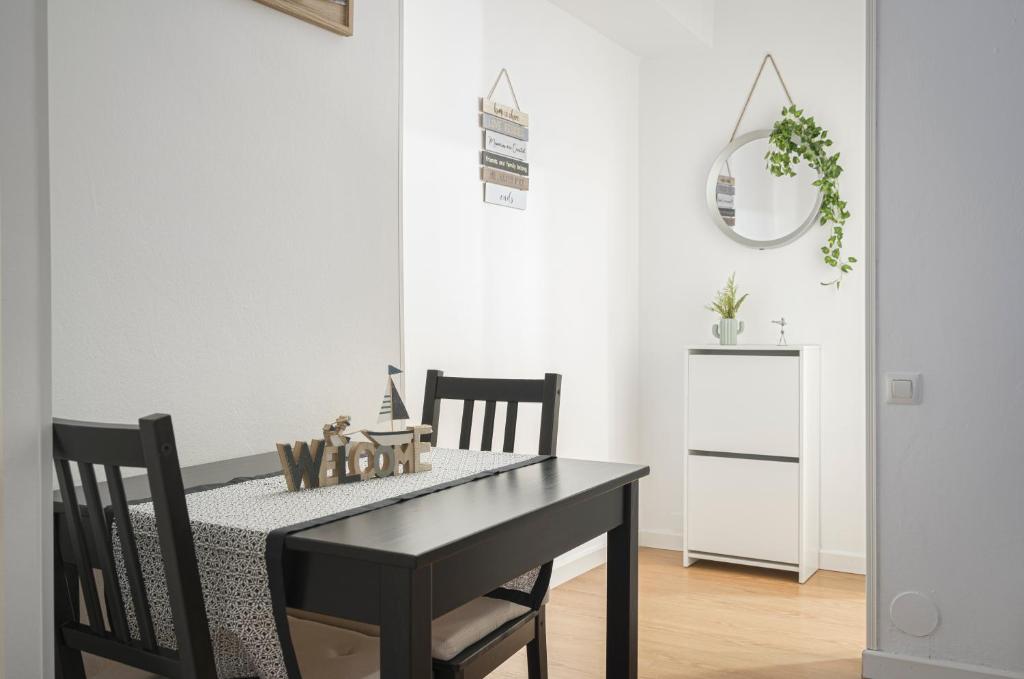 a dining room with a black table and chairs at Apartamento BS Oviedo Centro in Oviedo