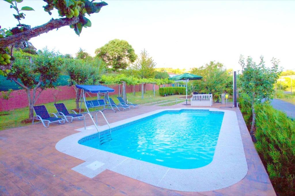 - une piscine avec une table et des chaises dans la cour dans l'établissement 5 bedrooms house with lake view private pool and garden at Cuntis, à Cuntis