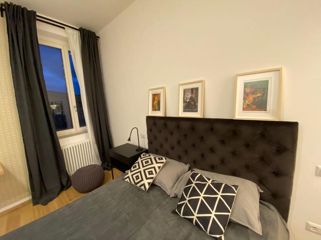 um quarto com uma cama com uma cabeceira preta e uma janela em DIECI at Spanish Step - Belsiana Luxury Apartment em Roma