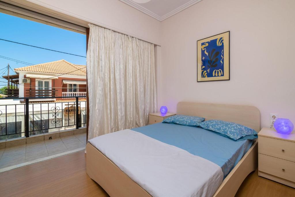 a bedroom with a bed and a large window at Natasas Apartments in Alykes
