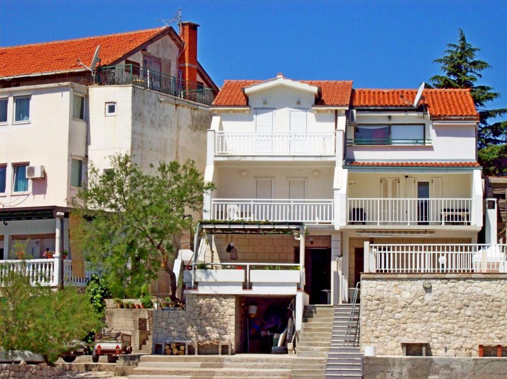 una gran casa blanca con techo rojo en Apartments Mara, en Klek
