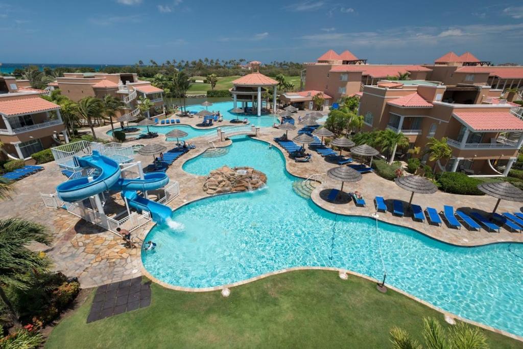 
a beach with a pool and a swimming pool at All Inclusive - Divi Village Golf and Beach Resort in Palm-Eagle Beach
