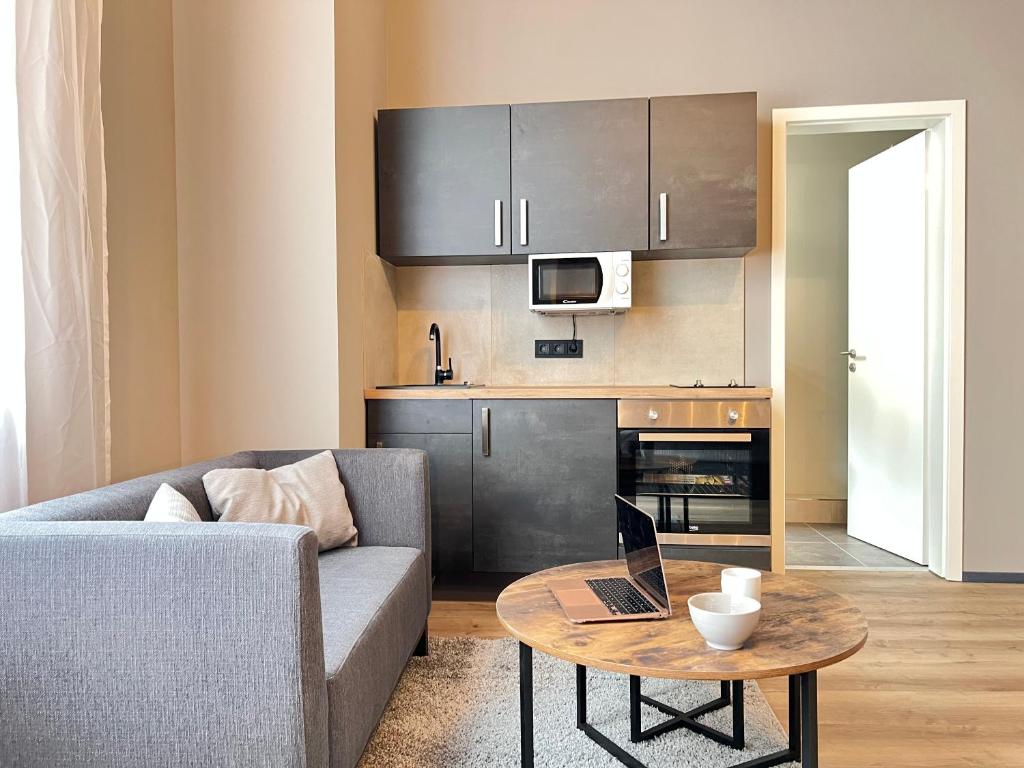 Una sala de estar con un sofá y una mesa con una computadora portátil. en Apartment an der Altstadt # 1, en Hameln