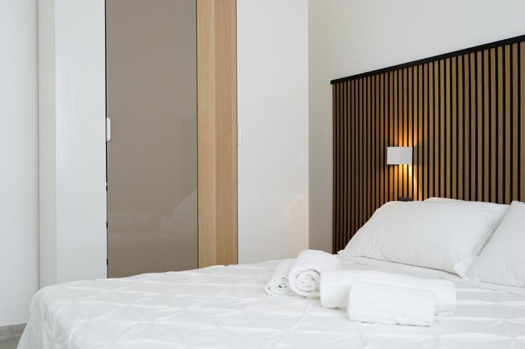 una camera da letto con un letto bianco e asciugamani di Villa Costantino a Pompei