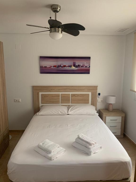 Un dormitorio con una cama con dos toallas encima. en Apartamentoen la playa, 200 Mts de la playa Nuevo, en Santa Pola