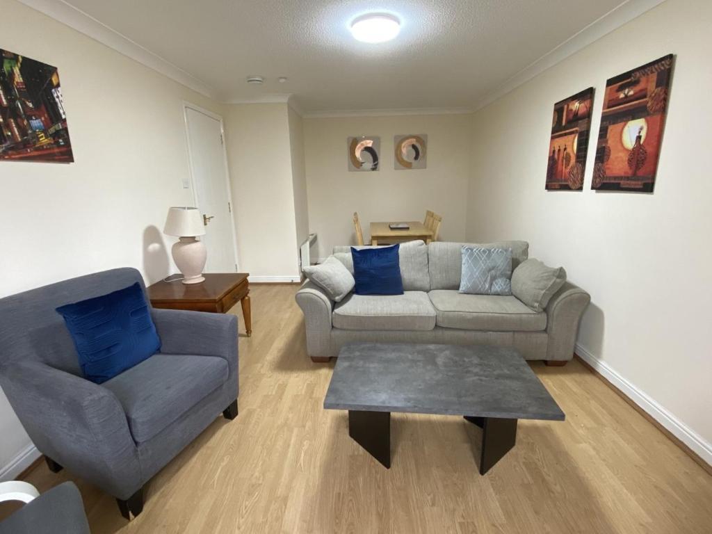 uma sala de estar com um sofá e uma cadeira em Pure Apartments Dunfermline East - Dalgety Bay em Saint Davids