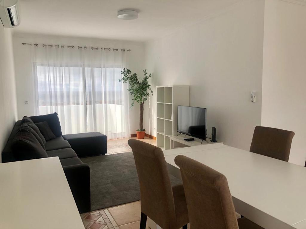 Una sala de estar con una mesa blanca y un sofá. en Azores Terrace Apartment T2, en Ponta Delgada