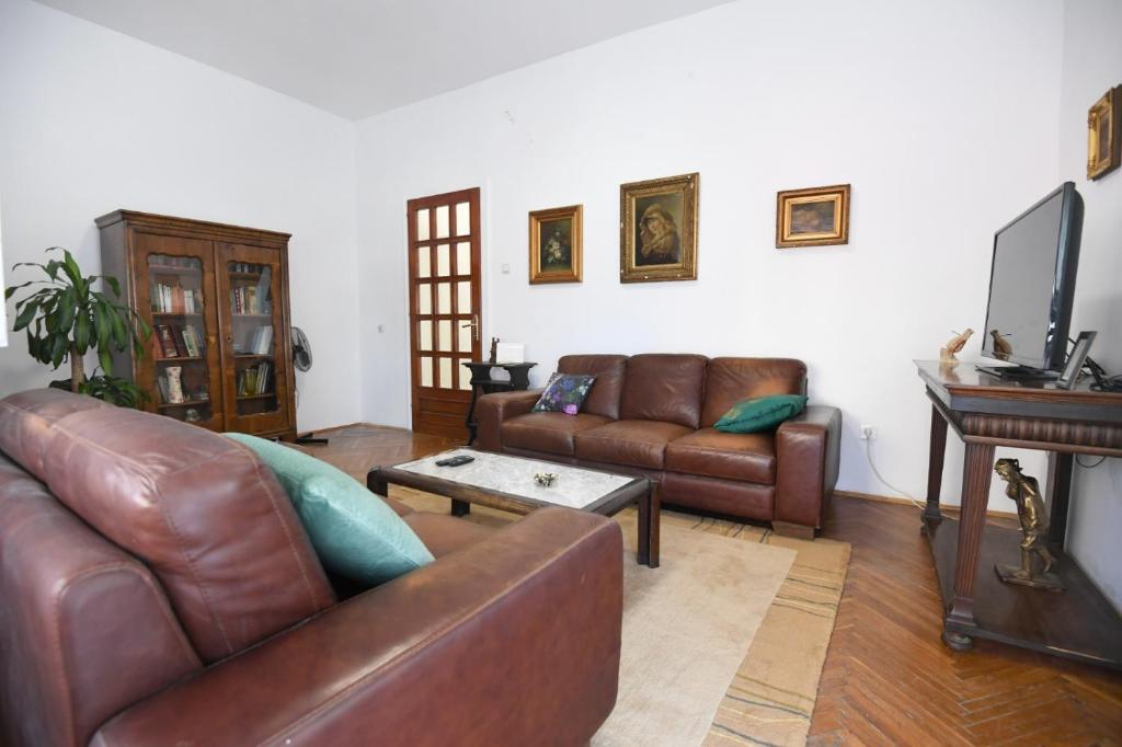 uma sala de estar com mobiliário de couro castanho e uma televisão em City center. Beautiful 130m2 apartmant, sea view em Zadar