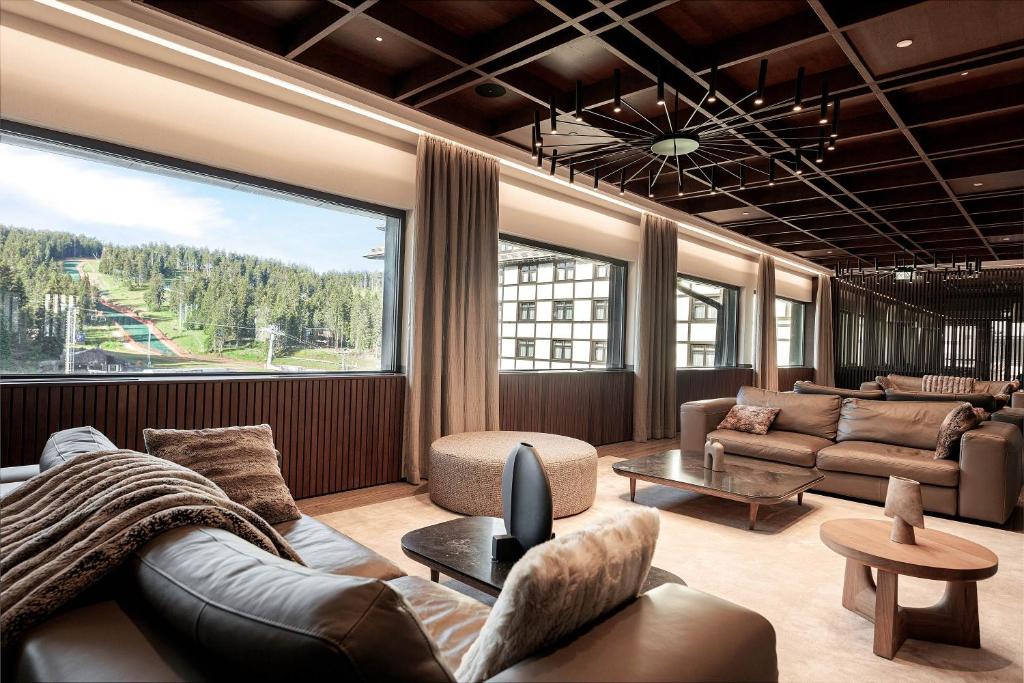 ein Wohnzimmer mit Sofa und großem Fenster in der Unterkunft Hotel Grand Kopaonik in Kopaonik