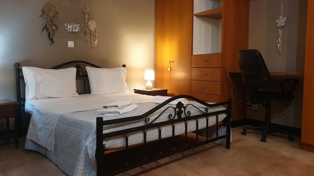 a bedroom with a bed with a desk and a chair at Andreas&Dinas sweet home in Corfu