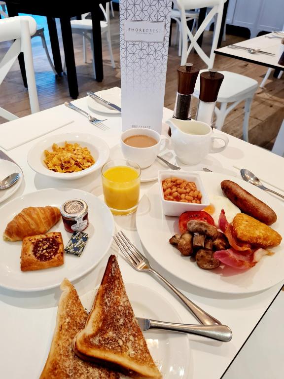 a table with plates of breakfast food on it at St Moritz Hotel and Cowshed Spa in Polzeath