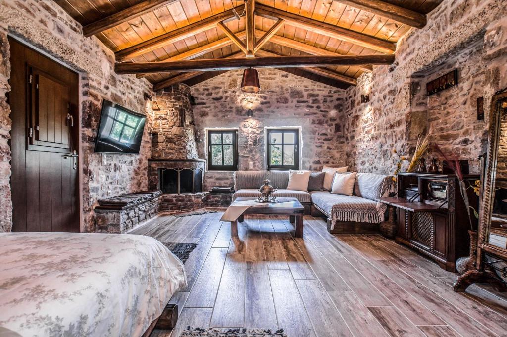 a bedroom with a bed and a couch and a fireplace at Karyoupolis Lounge Cave House in Gythio