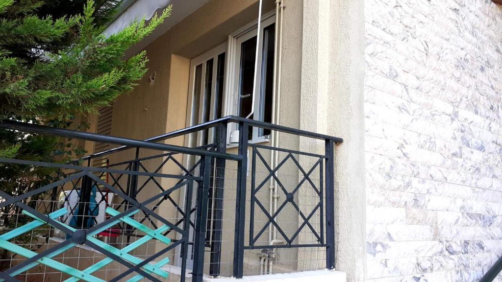uma varanda com um corrimão de ferro forjado num edifício em Immaculate 2-Bed Apartment em Glyka Nera