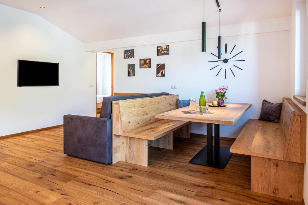 sala de estar con mesa y sofá en Luisl Hof - Apartment Vinum en Cornaiano