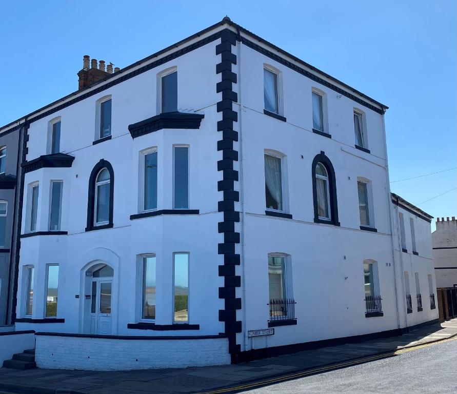 an old white building with a black pillar at Eastcliffe Penthouse, 2 beds & bathrooms with parking in Cleethorpes