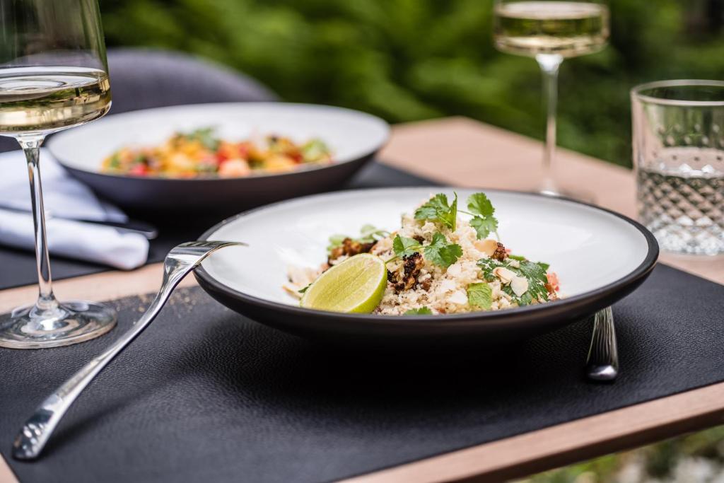 a table with two plates of food and glasses of wine at MOOONS Vienna in Vienna