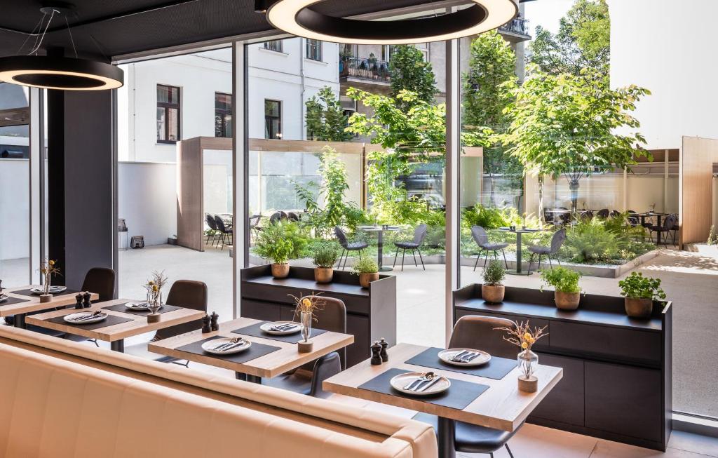 a restaurant with tables and chairs and windows at MOOONS Vienna in Vienna
