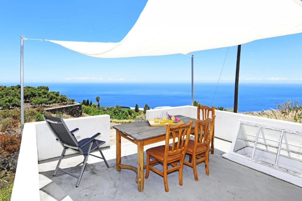 a table and chairs on a patio with a view of the ocean at Casa Nonito in Tijarafe